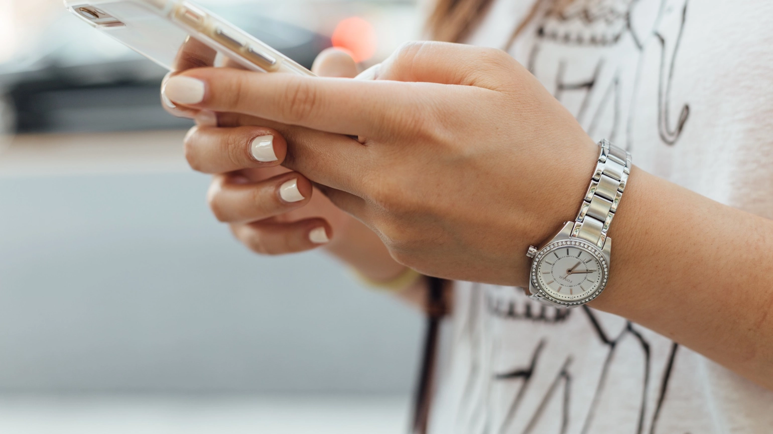 The hand of a woman using her phone