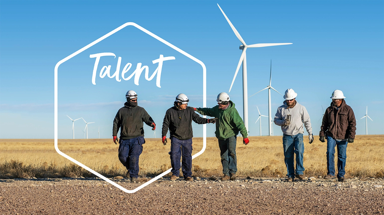 Example of an image from the report design with a group of bp workers walking together in a wind farm field and an illustration with the title talent behind them