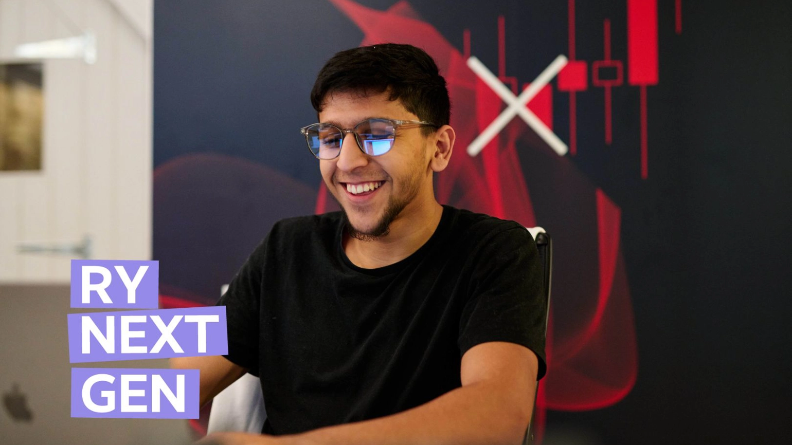 Radley Yeldar intern Mo sits in front of a computer, smiling