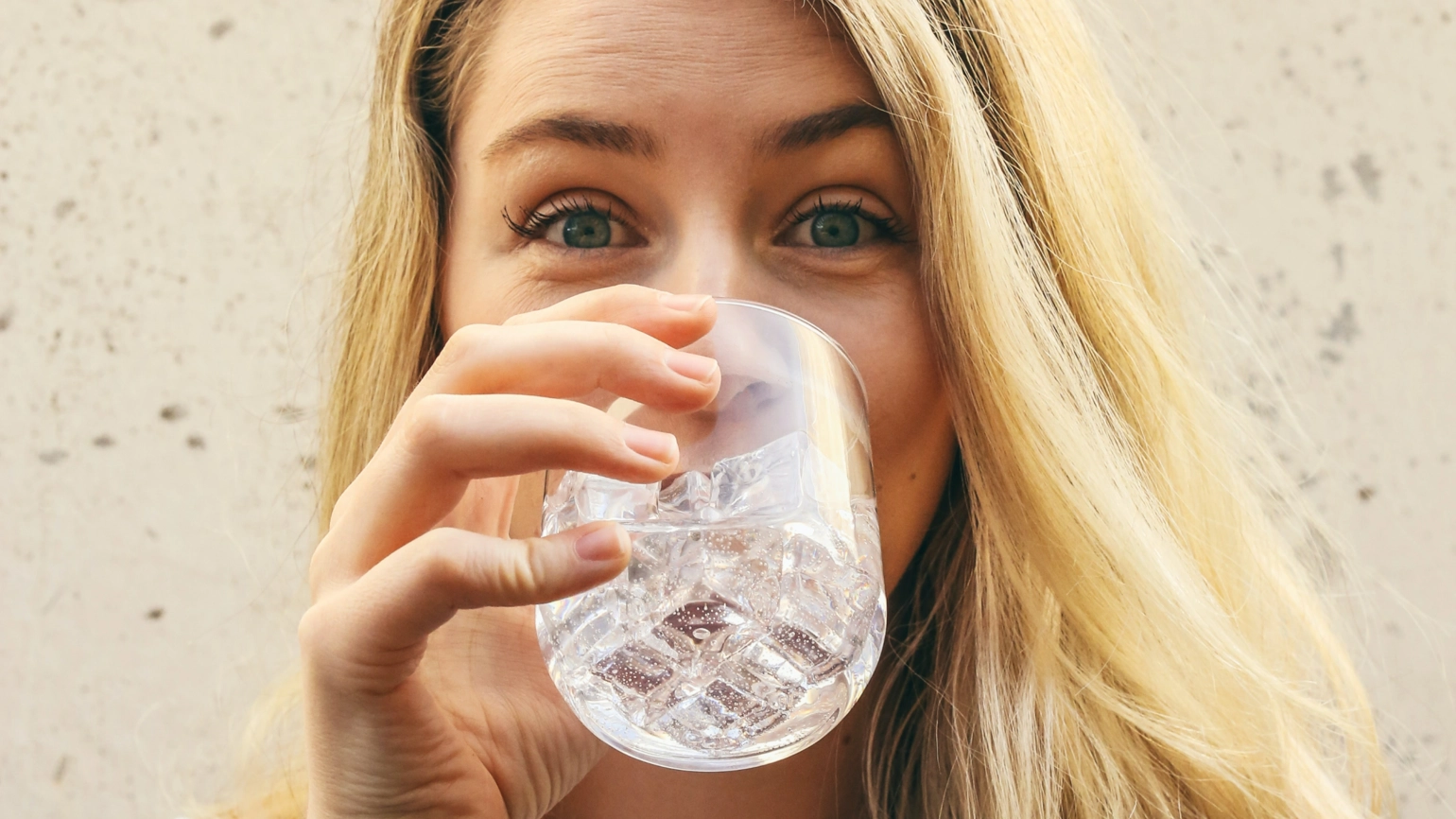 A blonde girl drinks water