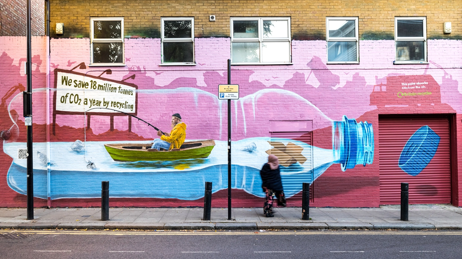 A face-fronted view of the graffiti of a man goes fishing inside a plastic bottle