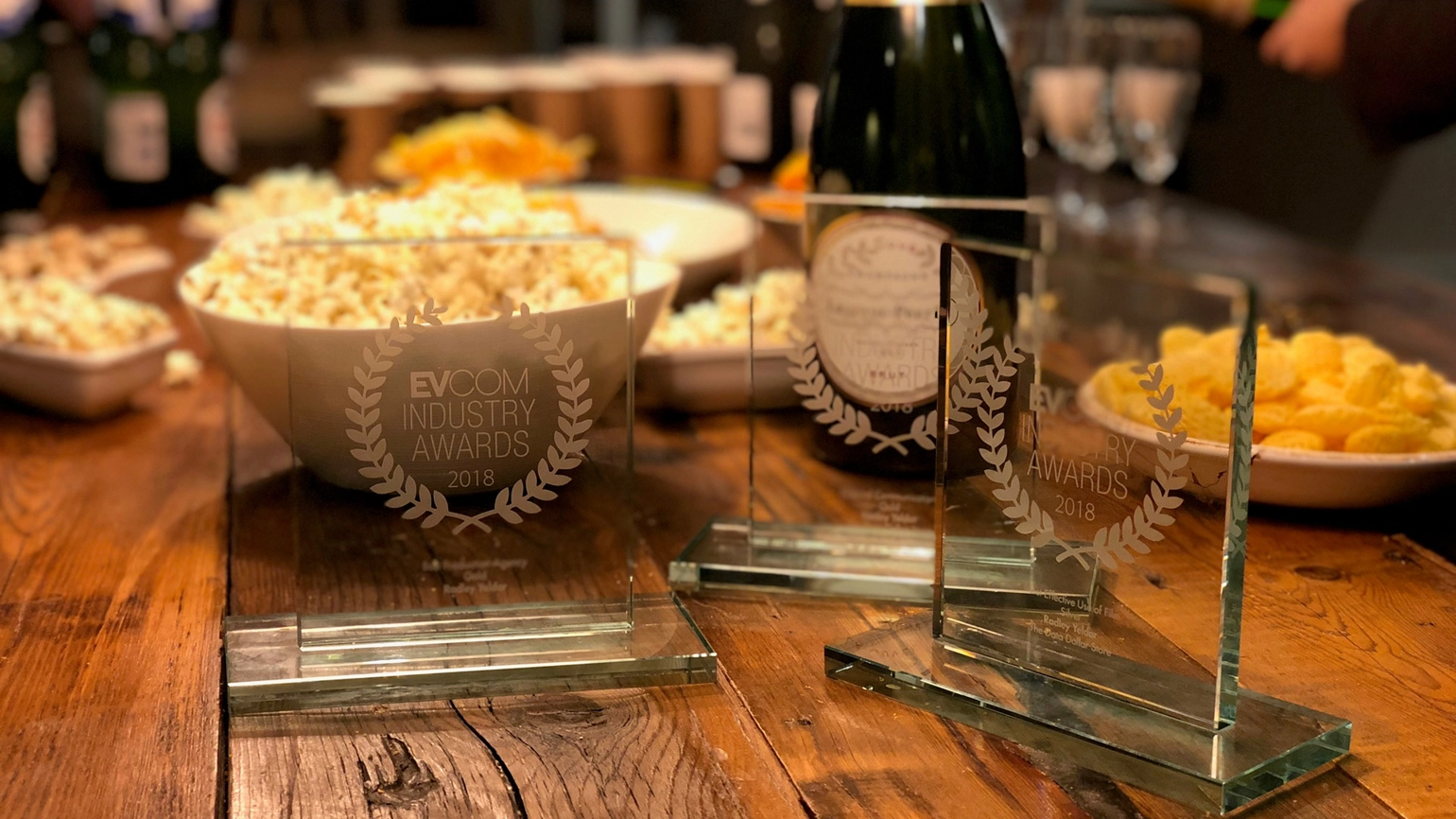 3 awards on table with popcorn and champagne
