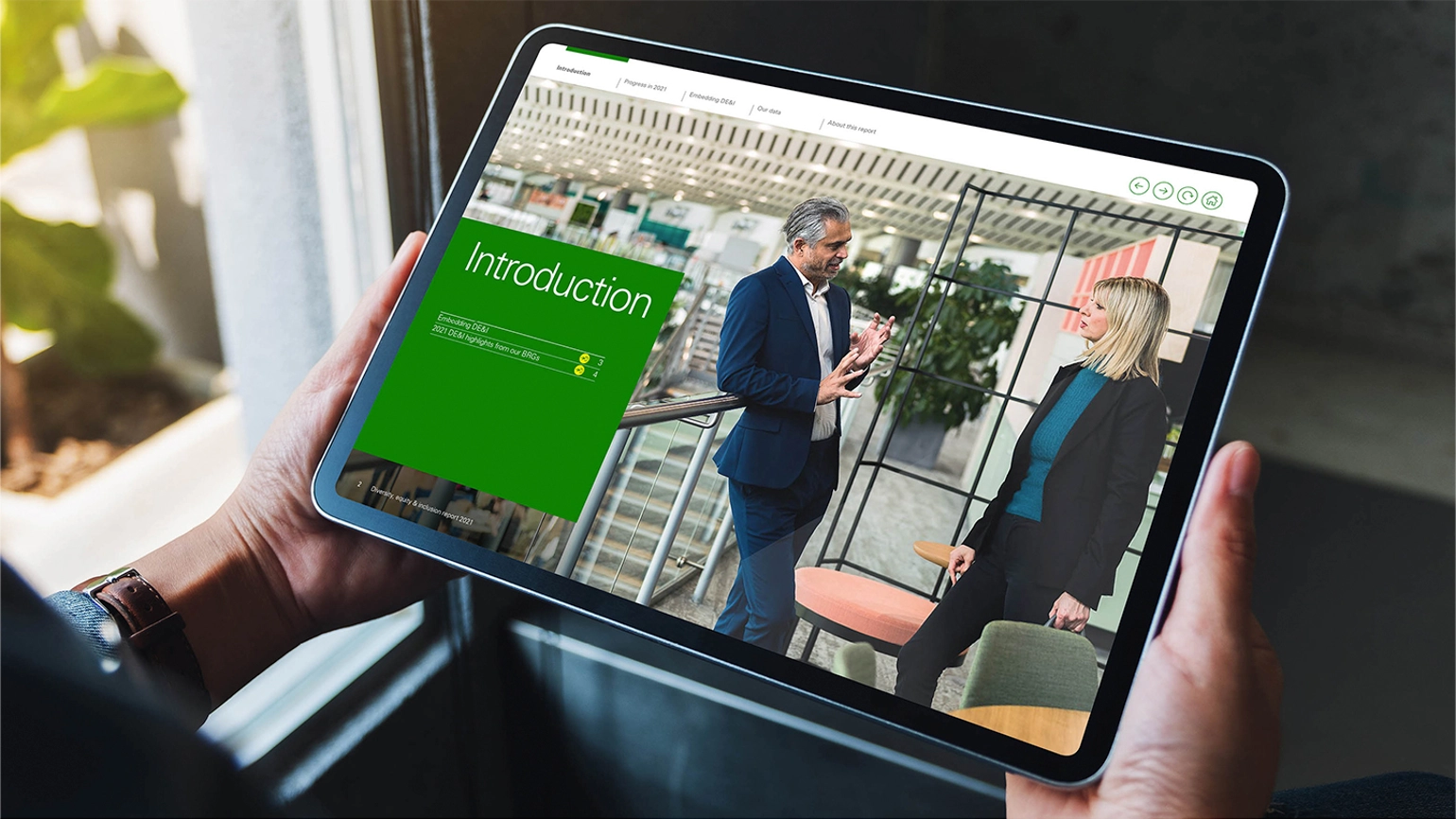 Example of report design within a tablet with an image of a man and a woman in conversation in the office on the right and then the title of introduction on the left