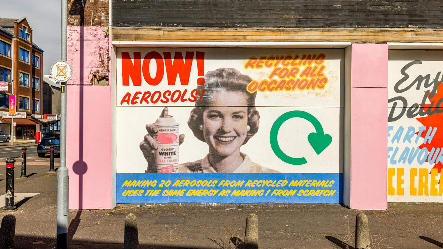 A wall-painted poster on the street with a woman carrying a spray