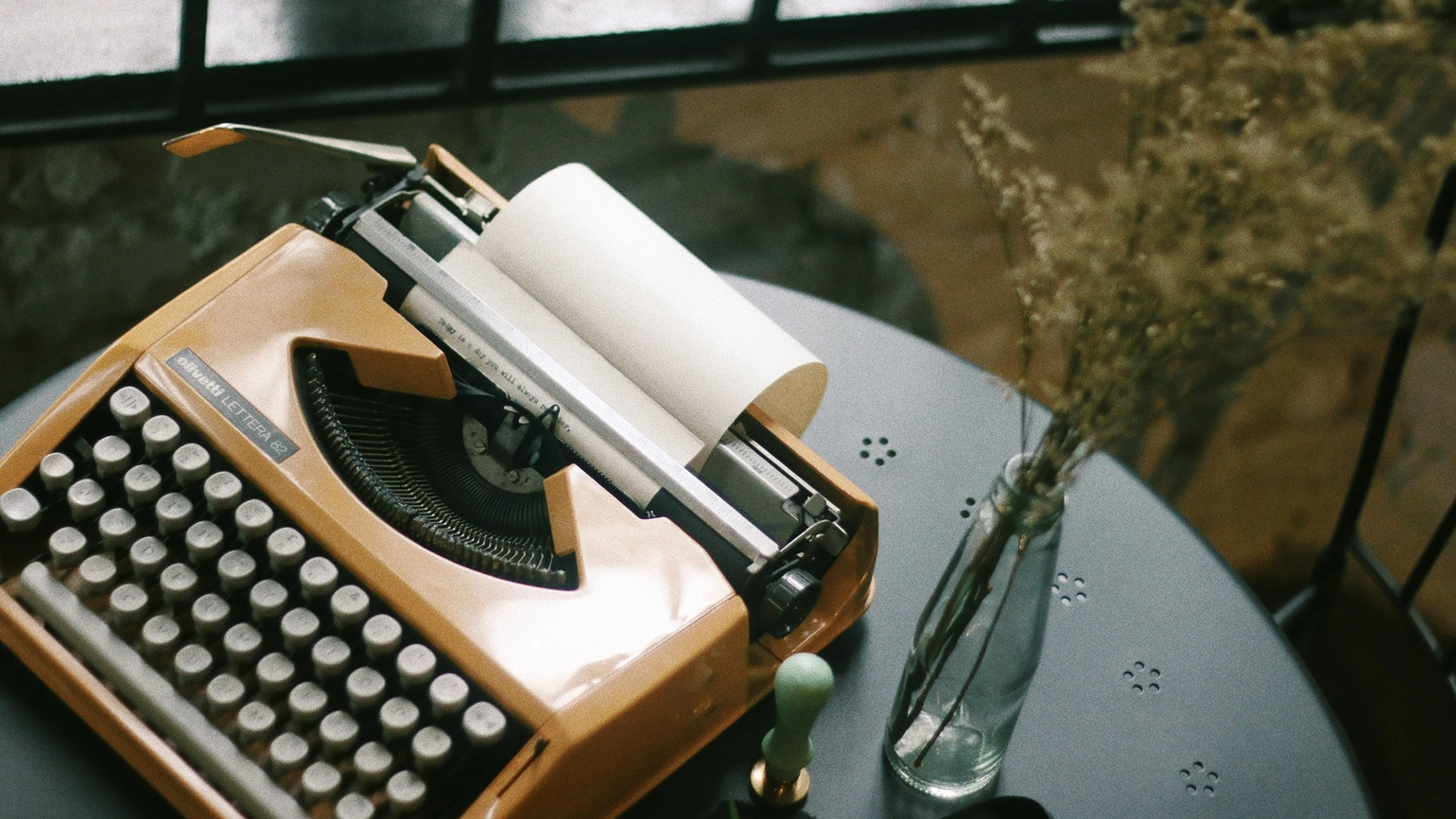 An orange typewriter on a table 