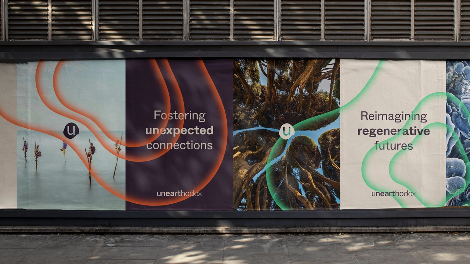 Outdoor poster adverts showing wave patterns of Unearthodox branding, one reads 'Fostering unexpected connections' another reads 'Reimagining regenerative futures'